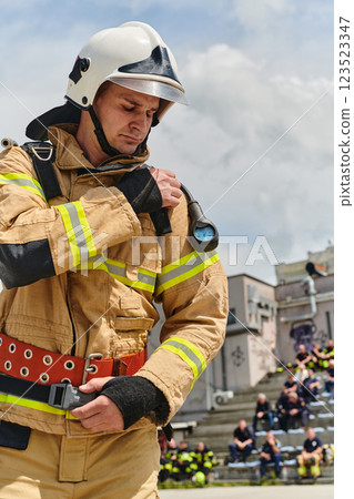 A firefighter dons the essential components of their professional gear, embodying resilience, commitment, and readiness as they gear up for a hazardous firefighting mission, a testament to their 123523347