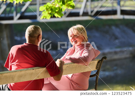 Elderly couple finding solace and joy as they rest on a park bench, engaged in heartfelt conversation, following a rejuvenating strol a testament to the enduring companionship and serene connection 123523475
