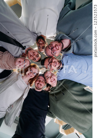 In a modern office, a group of young business professionals is captured in a warm and embracing hug, reflecting the spirit of unity, collaboration, and shared success in their dynamic workplace. In a modern office, a group of young business professionals is captured in a warm and embracing hug, reflecting the spirit of unity, collaboration, and shared success in their dynamic workplace. 123523573