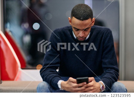 Young African American work in coworking space using smartphone analyzing online market trends, focused man worker reading financial news or browsing internet on phone. Technology concept 123523595