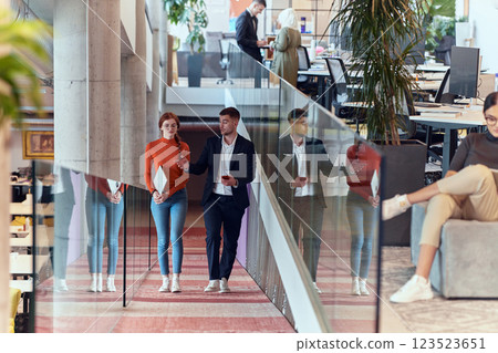 In the dynamic environment of a modern startup company, the director engages in a discussion with his young business colleague while they walk, reflecting the spirit of collaboration and innovation in In the dynamic environment of a modern startup company, the director engages in a discussion with his young business colleague while they walk, reflecting the spirit of collaboration and innovation in 123523651