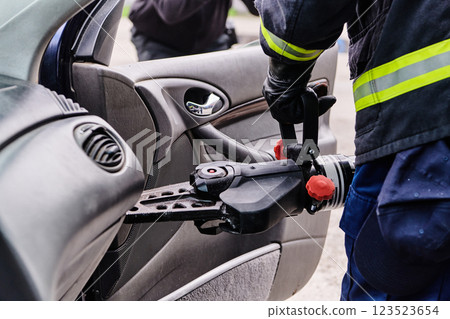 A dedicated team of professional firefighters employs specialized tools to cut and break through vehicle wreckage, showcasing their skilled collaboration and swift response in rescuing individuals 123523654