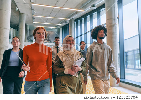 In the sleek corridors of a modern startup office, a diverse group of colleagues, led by their director, confidently stride forward, symbolizing collective success and the journey toward new business 123523704