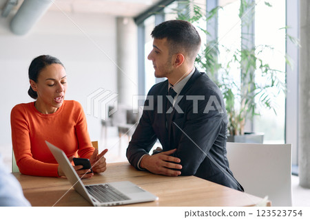 A young, diverse business team sitting together in a modern office, exchanging ideas and business plans, fostering collaboration and innovation for future success. 123523754