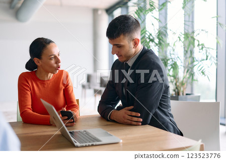 A young, diverse business team sitting together in a modern office, exchanging ideas and business plans, fostering collaboration and innovation for future success. A young, diverse business team sitting together in a modern office, exchanging ideas and business plans, fostering collaboration and innovation for future success. 123523776
