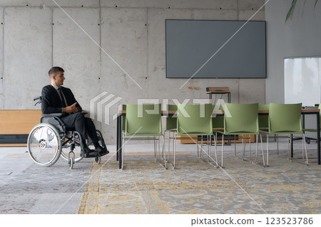 A director in a wheelchair sitting alone in an empty office, deeply reflecting on business strategies and decisions, contemplating the path forward with focused determination. A director in a wheelchair sitting alone in an empty office, deeply reflecting on business strategies and decisions, contemplating the path forward with focused determination. 123523786