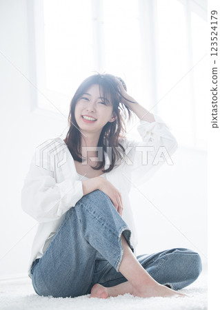 A refreshing woman looking at the camera as she pushes her hair back, full body hair care, beauty and beauty, languid expression A refreshing woman looking at the camera as she pushes her hair back, full body hair care, beauty and beauty, languid expression 123524179