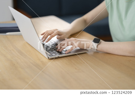 一位 30 多歲女性的手正在使用筆記型電腦 123524209