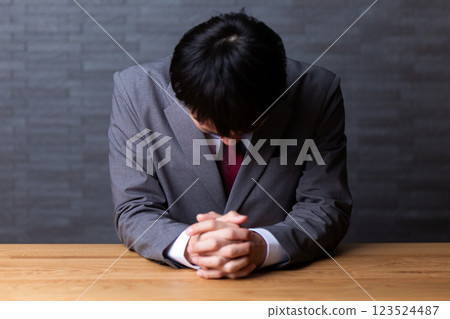 一位身穿灰色西裝、憂心忡忡的中年男性商人 一位身穿灰色西裝、憂心忡忡的中年男性商人 123524487