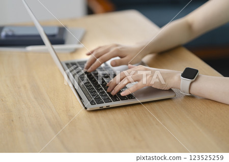 一位 40 多歲女性的手正在使用筆記型電腦 123525259