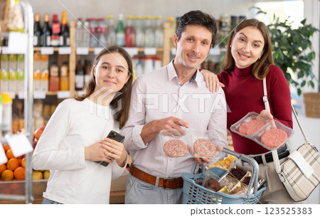 Family with teenage girl choosing hamburger in grocery 123525383