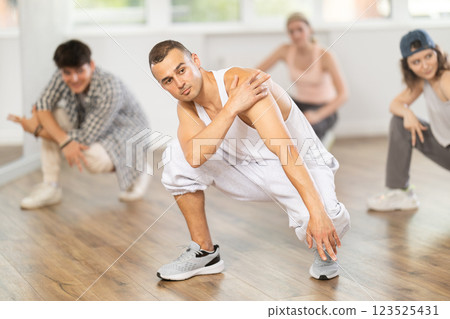 Teacher and her students squatting down and perform hip hop dance Teacher and her students squatting down and perform hip hop dance 123525431