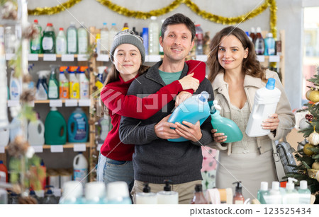 Family choosing cleaning products in festively decorated household store Family choosing cleaning products in festively decorated household store 123525434