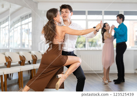 Hispanic guy and young woman engrossed in passionate tango 123525439