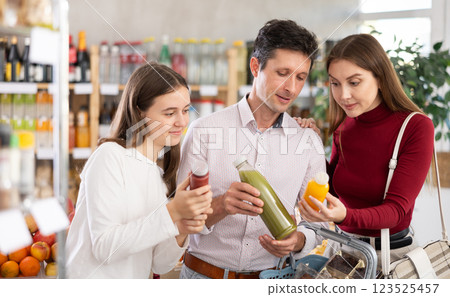 Family with teenage girl choosing smoothie in grocery 123525457