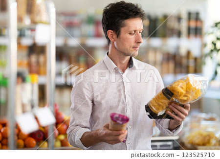 Adult man choosing pasta in grocery store 123525710