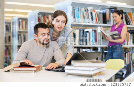 Woman and man studying together at library Woman and man studying together at library 123525757