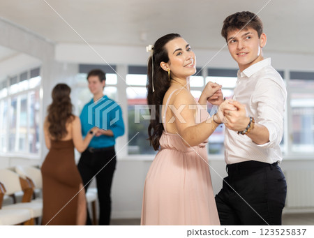 Latin American guy and dark-haired girl performing kizomba in dance studio 123525837