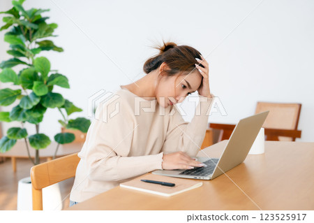 Thoughtful tired woman working on laptop computer looking on screen thinking solving problem 123525917