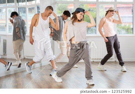 Group of young people perform choreographic exercises and teaches energetic mobile social dance waacking together Group of young people perform choreographic exercises and teaches energetic mobile social dance waacking together 123525992