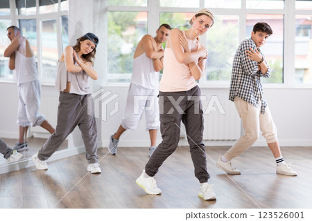 Active group sporty people practicing hip-hop dance in training hall during dancing classes 123526001