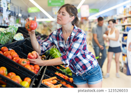 Portrait of young woman looking for fresh organic greens on supermarket Portrait of young woman looking for fresh organic greens on supermarket 123526033