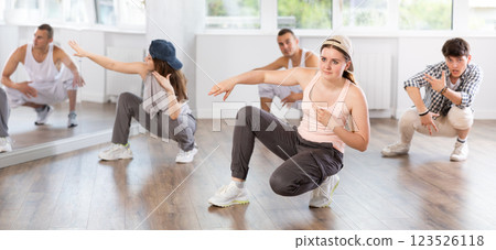 Teacher and her students squatting down and perform hip hop dance Teacher and her students squatting down and perform hip hop dance 123526118