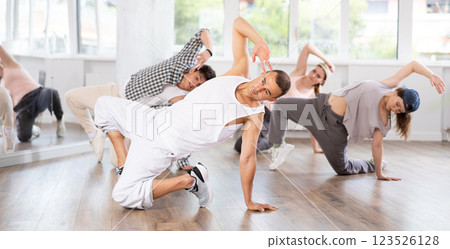 Group of young friends learn group dances - hip-hop and breakdance in dance studio Group of young friends learn group dances - hip-hop and breakdance in dance studio 123526128