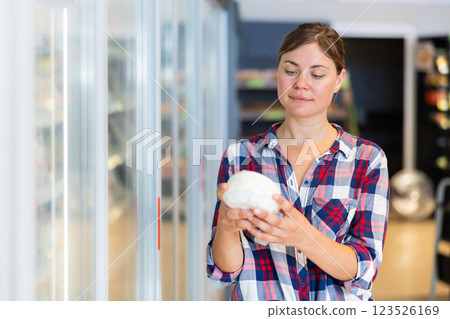 Woman shopping in supermarket, choosing dairy products Woman shopping in supermarket, choosing dairy products 123526169