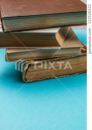 Old books stacked on a blue background creating a calm reading vibe 123526322
