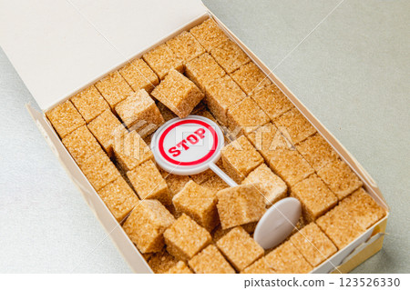 Brown sugar cubes arranged neatly in a box with a stop sign marker 123526330