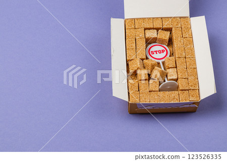 Creative display of sugar cubes with a stop sign on a purple surface 123526335