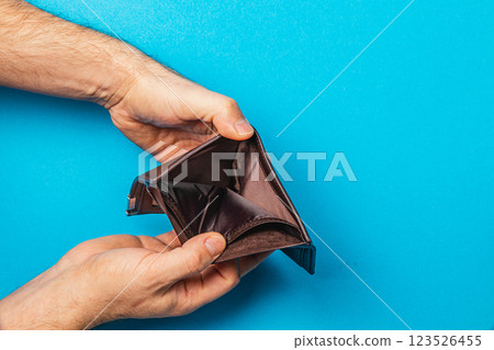 Struggling businessman examines empty wallet in financial crisis scene 123526455