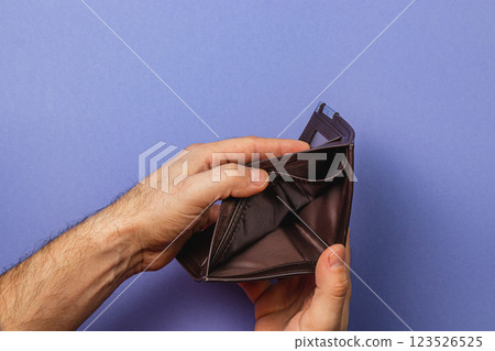 Businessman faces financial uncertainty while checking empty wallet Businessman faces financial uncertainty while checking empty wallet 123526525