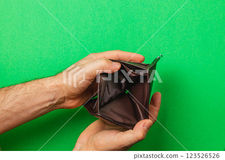 Two hands grasp a closed, empty wallet, symbolizing financial hardship Two hands grasp a closed, empty wallet, symbolizing financial hardship 123526526