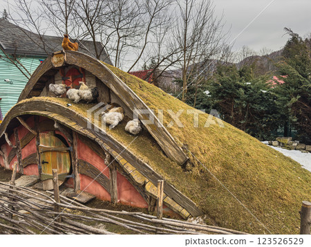 Unique grassy roof structure with chickens resting in a rural setting Unique grassy roof structure with chickens resting in a rural setting 123526529