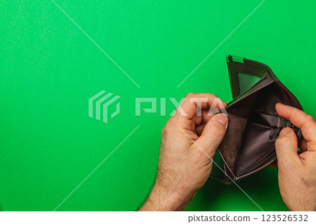 A man inspects his empty wallet amid financial struggles 123526532