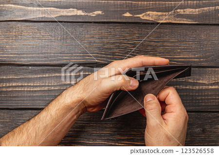 Struggling businessman examines an empty wallet during financial crisis 123526558