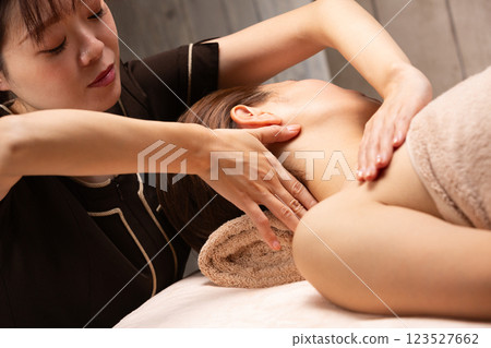 Young asian beautician doing neck massage. 123527662