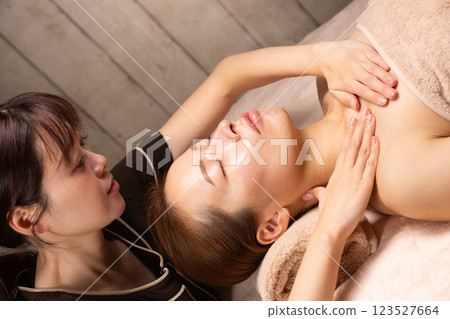 A young Asian woman is getting a decollete massage. 123527664
