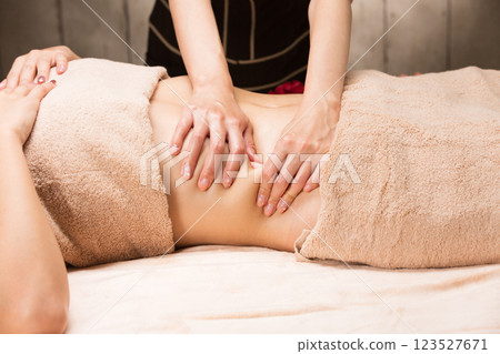 Young Asian woman getting a belly oil massage. Young Asian woman getting a belly oil massage. 123527671