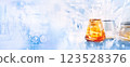 orange solution in flask and test tube in science research lab with blue banner background 123528376