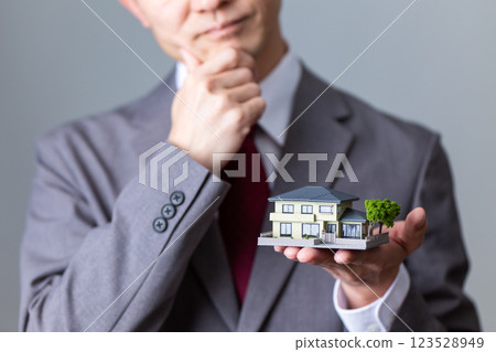 一位中年男性商人擔心房屋模型 123528949