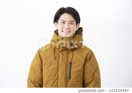 Man wearing down jacket, portrait, white background, looking at camera 123529367