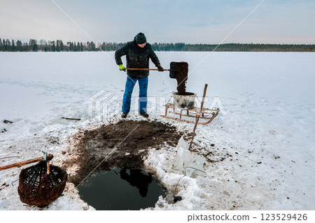 Ice hole sapropel extraction involves farmer using basket to collect goo, shoveling it to tank, and moving sludge via sled for organic agriculture. Ice hole sapropel extraction involves farmer using basket to collect goo, shoveling it to tank, and moving sludge via sled for organic agriculture. 123529426