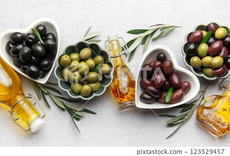 Black, green and kalamata olives with olive oil and olive branches Black, green and kalamata olives with olive oil and olive branches 123529457