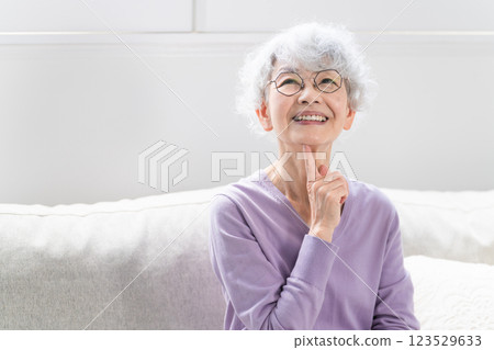 Senior woman sitting on sofa 123529633