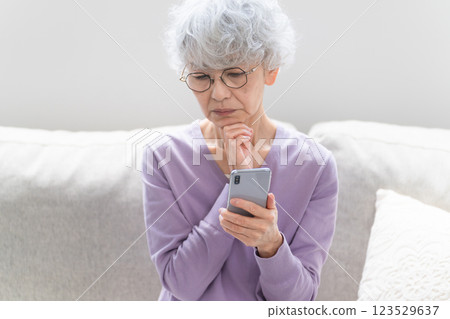 Senior woman operating a smartphone 123529637
