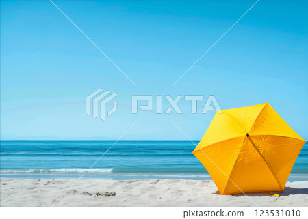 a yellow umbrella sitting on top of a sandy beach under a blue sky. generative ai 123531010