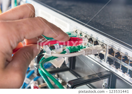 hand of engineer plugging in ethernet cable into server switch p hand of engineer plugging in ethernet cable into server switch p 123531441